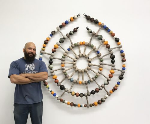 Sharif Bey poses with his artwork.